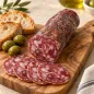 Preview: Salame al Tartufo mit Salami-Scheiben, Brot und grünen Oliven auf einem Holzbrett